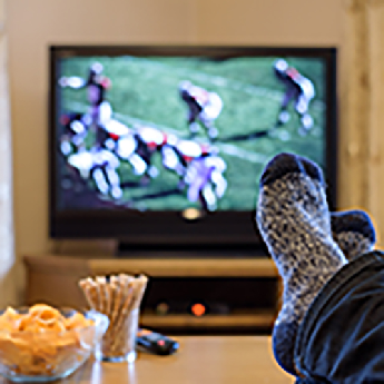 Football on TV with snacks on coffee table